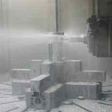 A multi-step tool being proved out on a machine under coolant spray