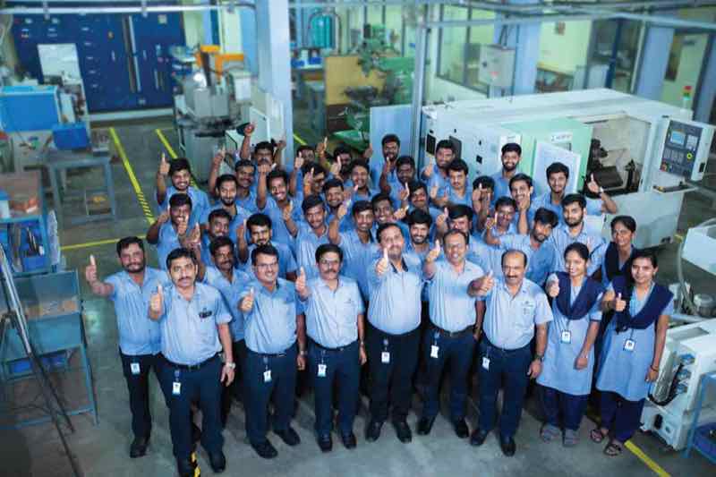 Mac Precitec India Private Limited's design, manufacturing and quality team on the shop floor in Peenya, standing among CNC machines